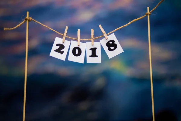 Mutlu yeni yıl 2018 metin, kağıtlara bulanıklık soyut mavi bokeh arka plan üzerinde clothespins ile — Stok fotoğraf
