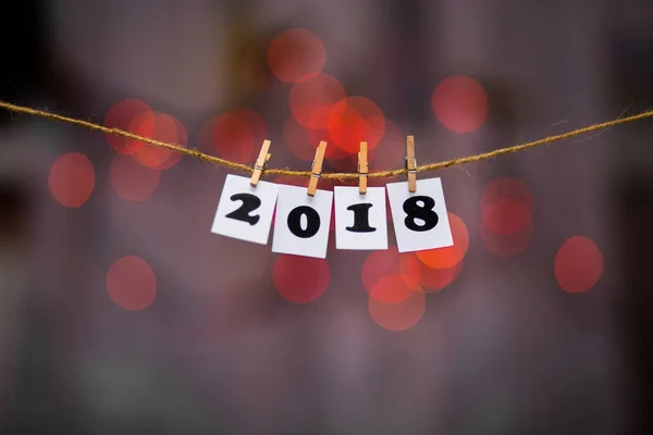 Mutlu yeni yıl 2018 metinle garland bokeh arka plan üzerinde kağıtlara clothespins ile — Stok fotoğraf