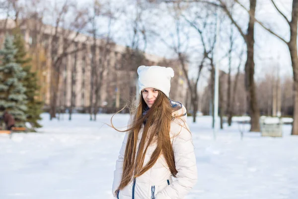 Porträtt av en vacker flicka i vitt med mycket långt hår i en snöig vinter — Stockfoto