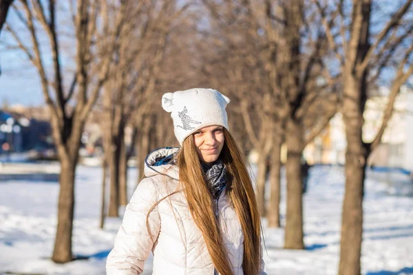 Portrét krásné dívky v bílém, s velmi dlouhými vlasy v zasněžené zimní — Stock fotografie