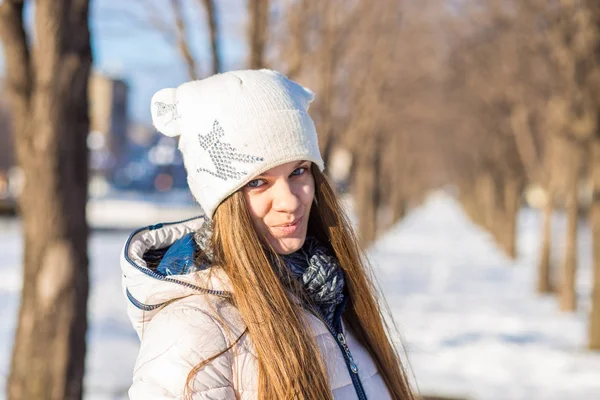 Portrét krásné dívky v bílém, s velmi dlouhými vlasy v zasněžené zimní — Stock fotografie
