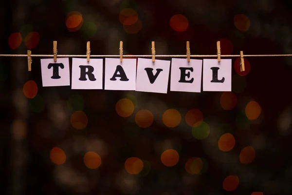 Travel text on papers with clothespins with garland bokeh on background — Stock Photo, Image