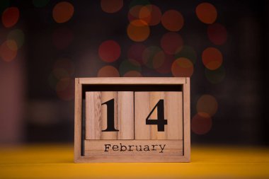 Gün 14 Şubat ahşap takvimde garland bokeh arka plan üzerinde ile ayarlayın. Sevgiliye arka plan