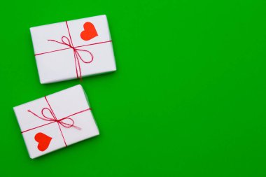 Kalpler yeşil zemin üzerine hediye kutuları seviyorum. Tebrik hediyesi. Aşk kavramı