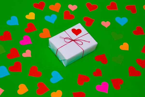 Caja Regalo Empaquetada Sobre Fondo Verde Con Muchos Corazones Multicolores —  Fotos de Stock