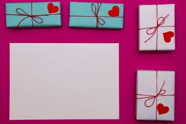 Mutlu Sevgililer günü kompozisyon: sevgi hediye kutuları üzerinde pembe bir arka plan, fotoğraf şablonu ile kağıt beyaz boş. Üstten Görünüm. Yukarıdan görüntülemek.