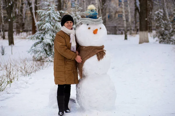 Mulher Sênior Feliz Esculpir Abraçar Grande Boneco Neve Real Parque — Fotografia de Stock