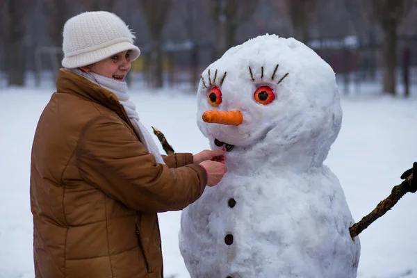 Mulher Sênior Feliz Esculpir Abraçar Grande Boneco Neve Real Parque — Fotografia de Stock