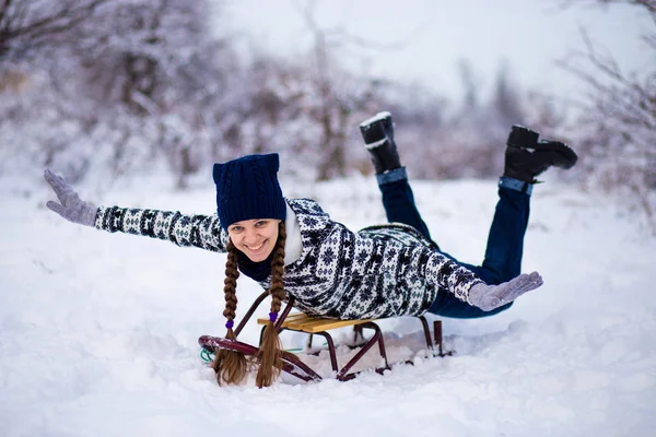 Crazy woman enjoy a sleigh ride. Woman sledding. Funny woman play outdoors in snow. Woman sled in Alps mountains in winter. Outdoor fun for Christmas vacation.