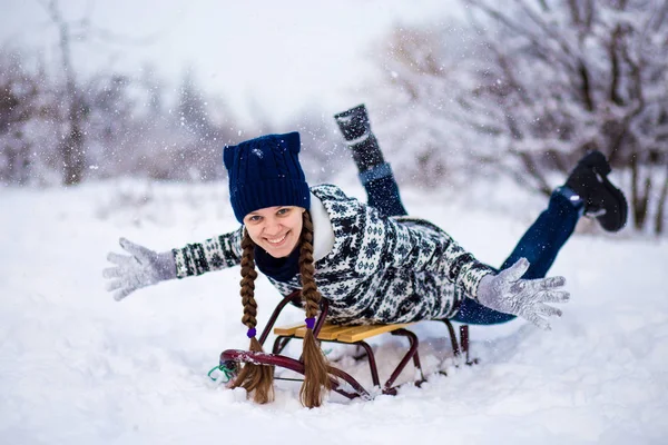 Crazy woman enjoy a sleigh ride. Woman sledding. Funny woman play outdoors in snow. Woman sled in Alps mountains in winter. Outdoor fun for Christmas vacation.