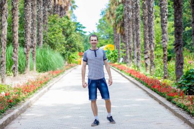 Genç mutlu Gezgin adam yürüyüş sokak palm ile tarafından