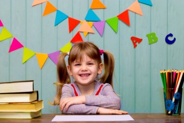 Sınıfta çok güzel kız portresi. Bir masada oturan ve eğitim liseli kızlar. Eğitim ve okul kavramı - birçok küçük kız okulda kitap