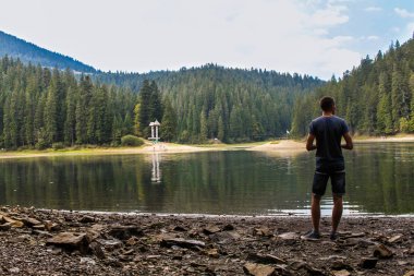 Yürüyüş dağ gölü, arkadan görünüm, uyum kavramı yakınındaki genç adam