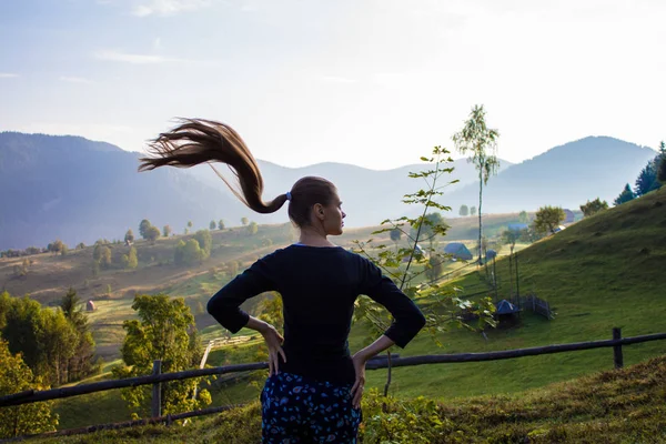 Tourist woman on top of mountains with blue sky. Woman enjoying free happiness in beautiful landscape. Travel concept