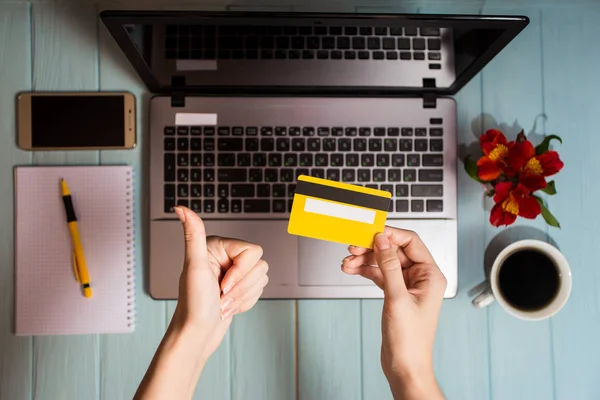 concept of online new technologies, shopping buy goods. woman buying with debit credit card and laptop in cafe. Top view. Flat lay