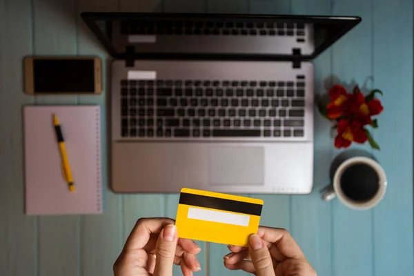 concept of online new technologies, shopping buy goods. woman buying with debit credit card and laptop in cafe. Top view. Flat lay