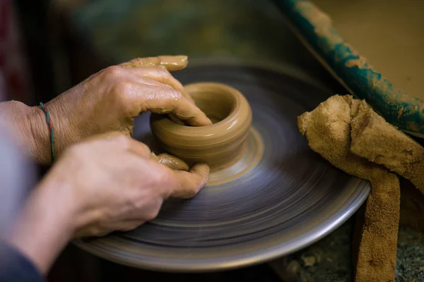 Sculpts in clay pot closeup. Modeling clay close-up. Caucasian man making vessel daytime of white clay in fast moving circle. Art, creativity. Ukraine, cultural traditions. Hobbies