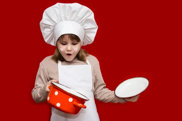 Niña Feliz Con Uniforme Chef Tiene Una Cacerola Aislada Rojo — Foto de Stock