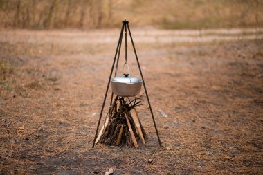 Ormanda kamp ateşinde yemek hazırlamak.