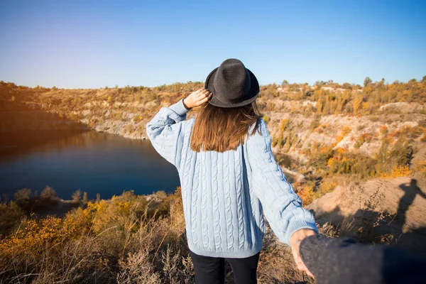 Turistkvinna som håller man för hand och går till sjön i höstfjällen. Följ mig koncept — Stockfoto