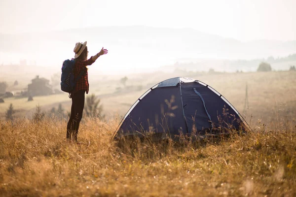 Úspěšná silueta pěší turistky na vrcholu hor, motivace a inspirace v krásném západu slunce. Žena pěší turistka s pažemi na vrcholu hory, inspirativní krajina. — Stock fotografie