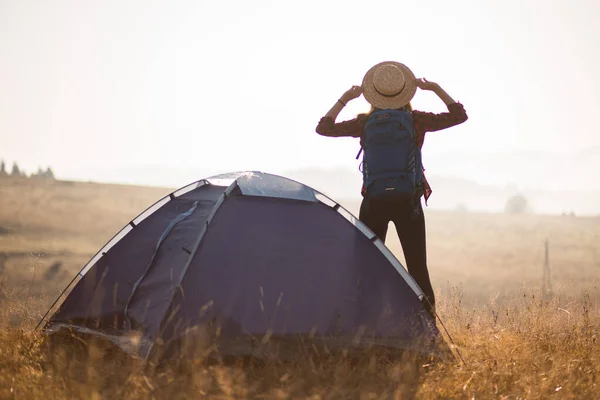 Úspěšná silueta pěší turistky na vrcholu hor, motivace a inspirace v krásném západu slunce. Žena pěší turistka s pažemi na vrcholu hory, inspirativní krajina. — Stock fotografie