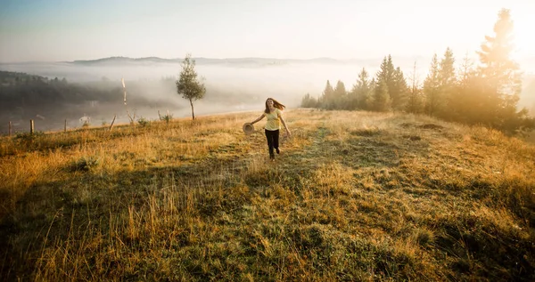 Chica con sombrero correr con felicidad en la cima de una montaña en otoño amanecer . — Foto de Stock