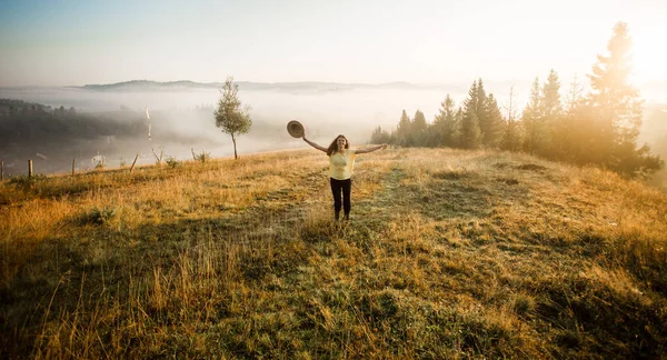 Chica con sombrero correr con felicidad en la cima de una montaña en otoño amanecer . — Foto de Stock
