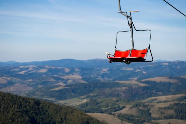 Крупним планом червоний стілець, що йде над деревами влітку на горі . — стокове фото