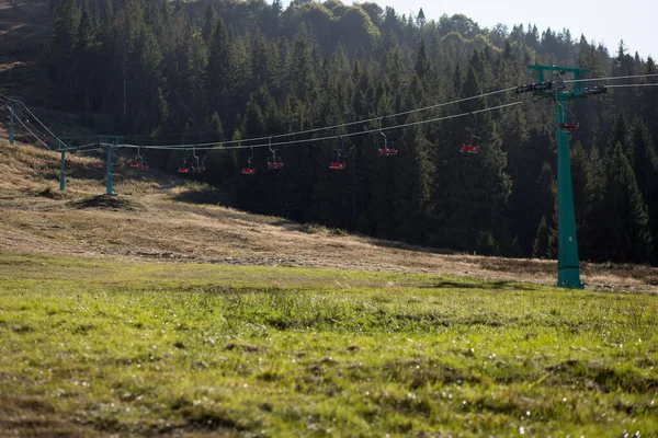 Oldalnézet piros szék lift lovagolni hegyek gyönyörű természet háttere. — Stock Fotó