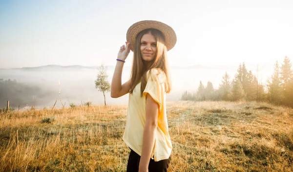 Młoda, beztroska kobieta ciesząca się naturą i słońcem w słomkowym kapeluszu — Zdjęcie stockowe