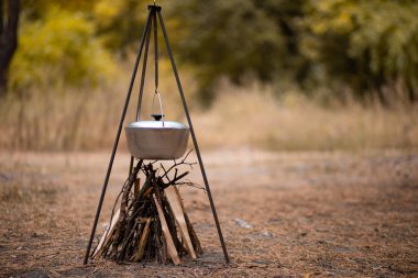 Ormanda kamp ateşinde yemek hazırlamak.