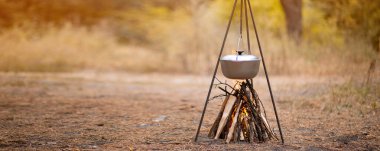 Ormanda kamp ateşinde yemek hazırlamak.