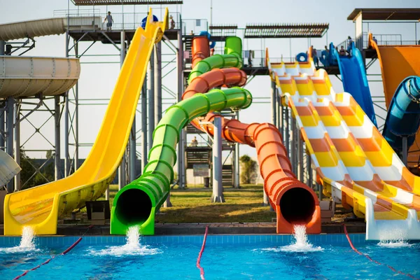 Kleurrijke glijbanen in outdoor waterpark in resort — Stockfoto