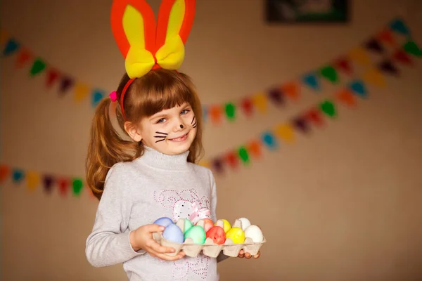 Sevimli küçük kız parlak Paskalya yortusu yumurta tutan tavşan kulakları ile — Stok fotoğraf