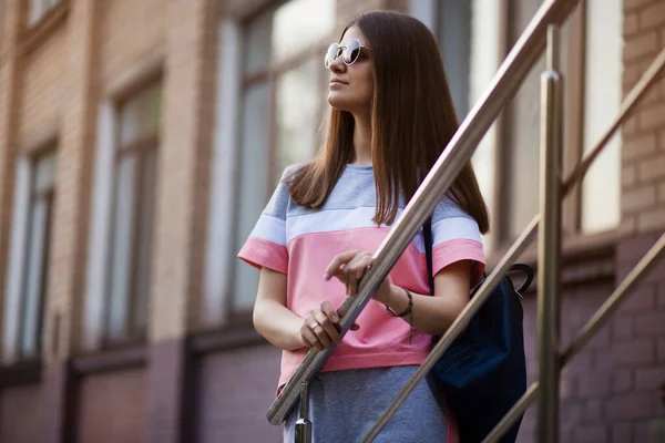 Portrait de jeune belle femme portant des lunettes de soleil marchant dans la rue de la ville. Concept de style de vie . — Photo
