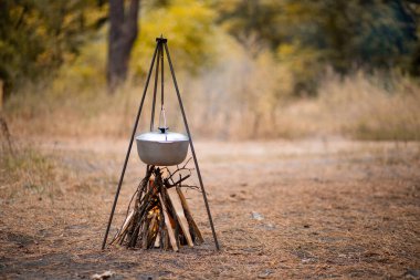 Sonbahar ormanlarında kamp ateşinde yemek hazırlamak.