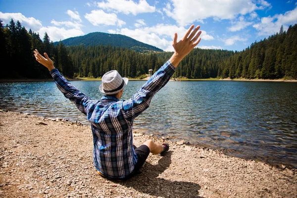 Free man with open arms near mountains lake. success. Travel and Freedom concept. Good life. Man enjoys moment alone with himself