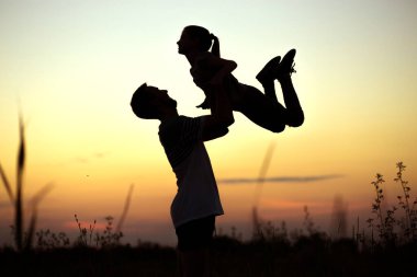 Gün batımında babasının mutlu kızını havaya fırlattığı siluet. Ailecek vakit geçiriyoruz. Mutlu Babalar Günü