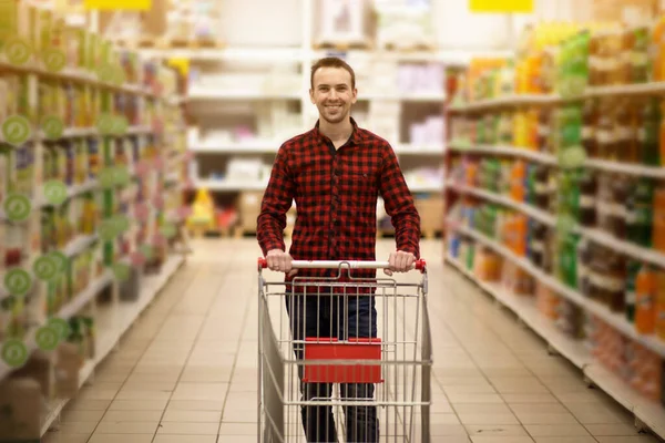 Przystojny Uśmiechnięty Mężczyzna Zakupy Supermarkecie Pchania Wózek — Zdjęcie stockowe