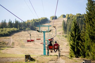 Pylypets, Ukrayna - 15 Eylül 2019: Dağ bisikletçileri dağda sandalyede kaldırıyorlar. Karpatlar, Ukrayna, kayak merkezi