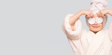 Beyaz arka planda izole edilmiş yüz temizleyicisiyle yüzü temizleyen pamuk tutacağı olan güzel bir kızın pankart görüntüsü. Mutlu kız makyajını sil ve kameraya bak. Sağlıklı, temiz cilt bakımının keyfini çıkar.