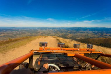 Dağın tepesinde turuncu bir kamyon ve mavi gökyüzü, içeriden manzaralı. tehlike yolculuğu