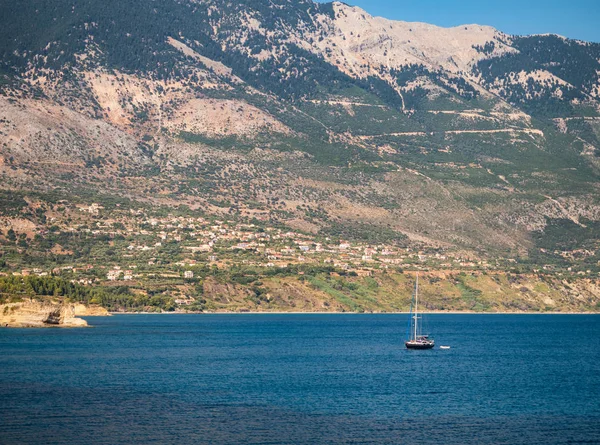 Μικρό Ιστιοφόρο Στην Θάλασσα Και Ένα Χωριό Στο Παρασκήνιο Κεφαλονιά — Φωτογραφία Αρχείου