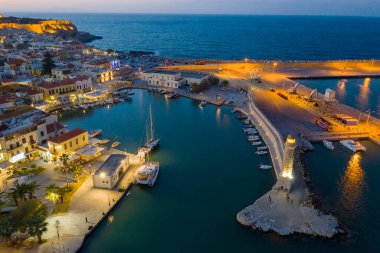 RETHIMNO - GREECE, OCTOBER 26, 2019: Aerial view of Rethymno city in Crete illuminated late in the afternoon clipart