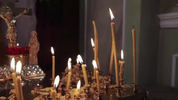Eine Nahaufnahme brennender Kerzen im Tempel — Stockvideo