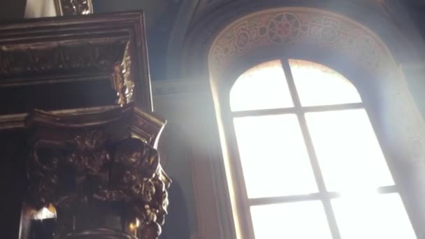 Een close-up van een venster in de tempel, waardoor de zon breekt — Stockvideo