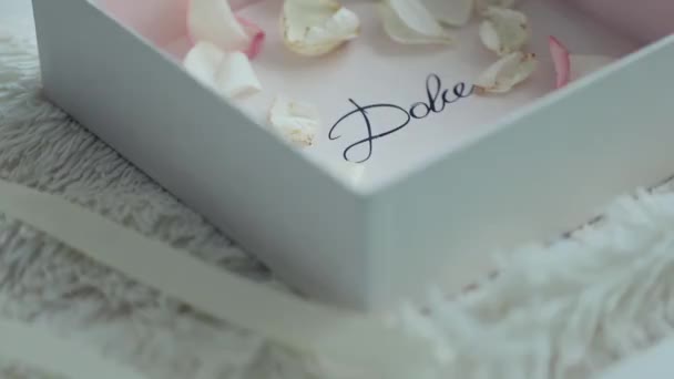 Маленькие лепестки белых роз в коробке — стоковое видео