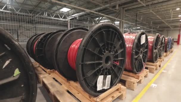 Grandes bobines avec fils électriques rouges sur d'énormes étagères dans une usine industrielle. Fabrication de câblage électrique pour voitures. frapper la caméra — Video