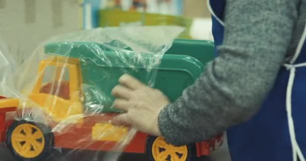 労働者はおもちゃの生産のためのプラスチック部品をパック 動画クリップ